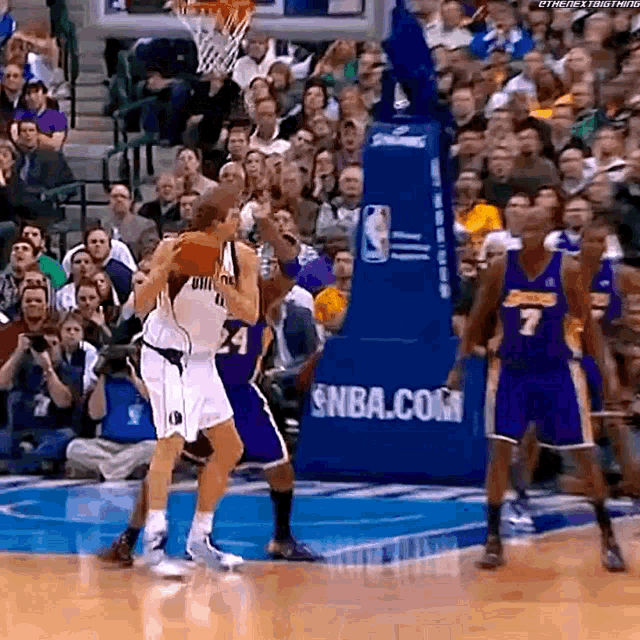 a basketball game is being played in front of an nba.com advertisement