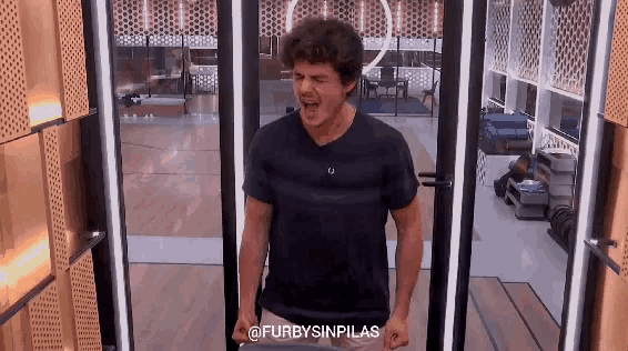 a man in a black shirt is standing in front of a glass door with the words furbysinpilas written on the bottom