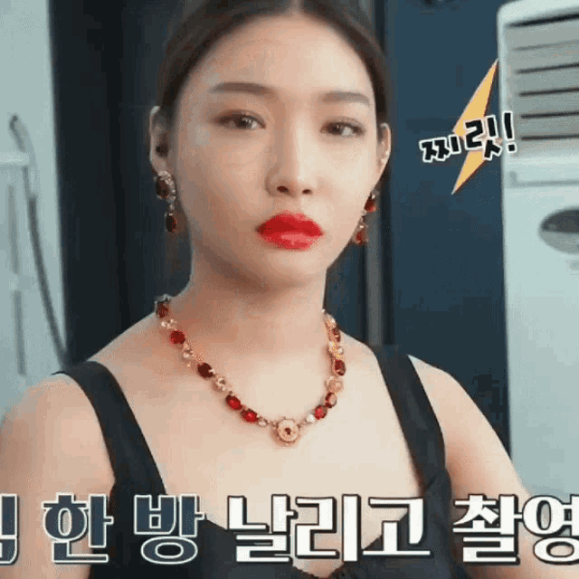 a woman wearing red lipstick and a necklace has a lightning bolt above her head