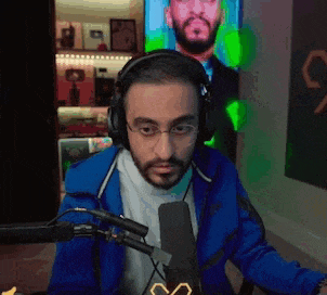 a man wearing headphones and glasses is talking into a microphone .