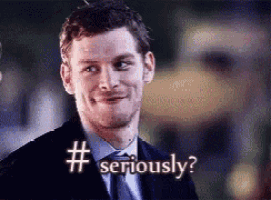 a man in a suit and tie is smiling and says " seriously "