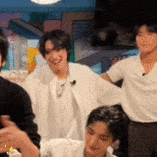 a group of people are sitting in a room and one of them is laughing .