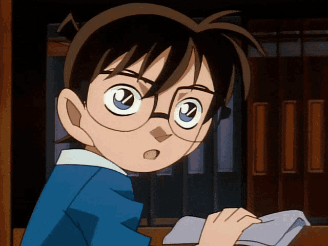 a boy wearing glasses is looking at something