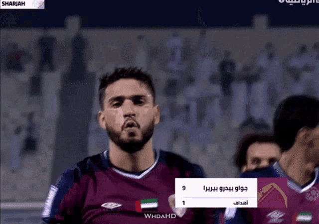a man with a beard is wearing a purple jersey with the united arab emirates flag on the front