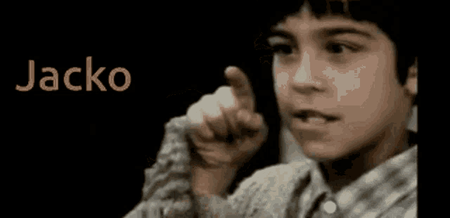 a young boy making a funny face with the name jacko behind him