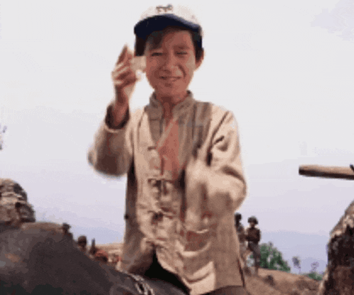 a young boy wearing a hat with the letter s on it is holding something in his hand