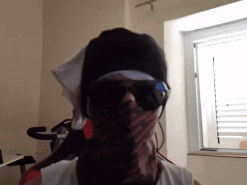 a person wearing sunglasses and a scarf around their neck