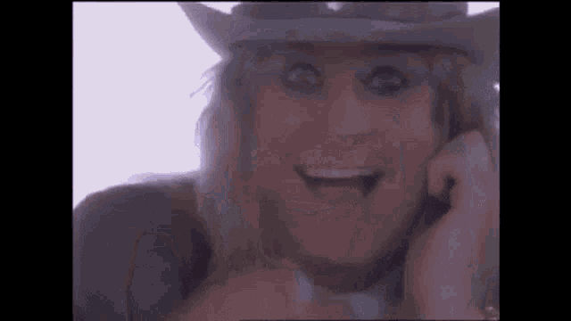 a close up of a person wearing a cowboy hat and smiling .