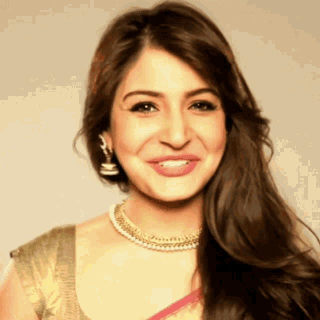 a woman wearing a pearl necklace and earrings smiles