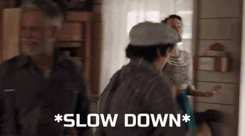 a group of people are standing in a room and one of them says slow down