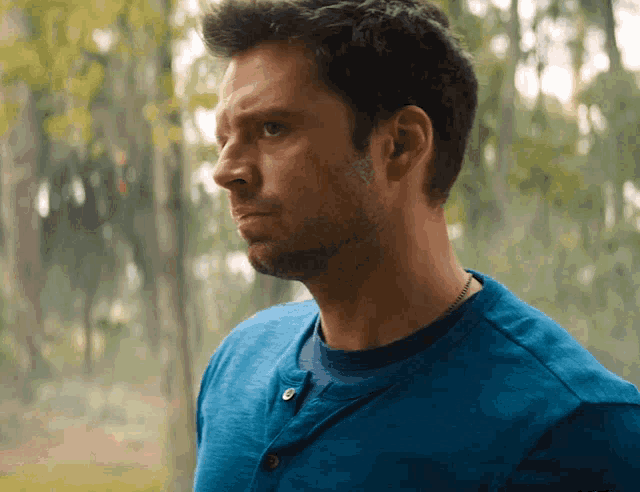 a man wearing a blue shirt with buttons on the front