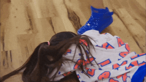 a girl laying on the floor wearing a shirt that says ' a ' on it