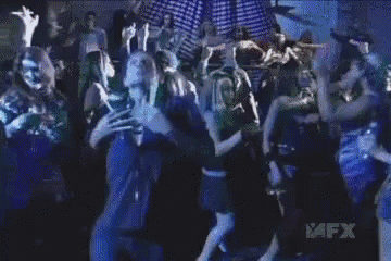 a man in a blue shirt is dancing in front of a crowd with the word avfx on the bottom