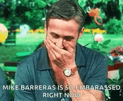 a man is covering his mouth with his hand and the words mike barrieras is so embarrassed right now