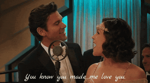 a man and woman singing into a microphone with the words you know you made me love you written below them