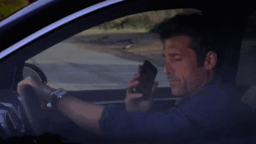 a man is driving a car while talking on a cell phone