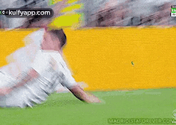 a soccer player is laying on the ground on a soccer field .