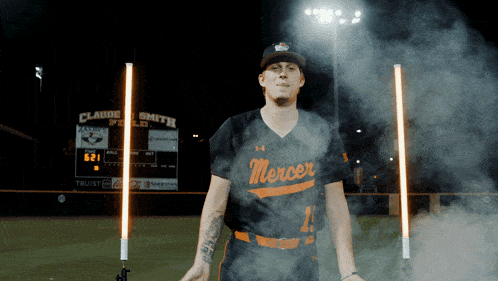 a baseball player wearing a mercer jersey stands on a field