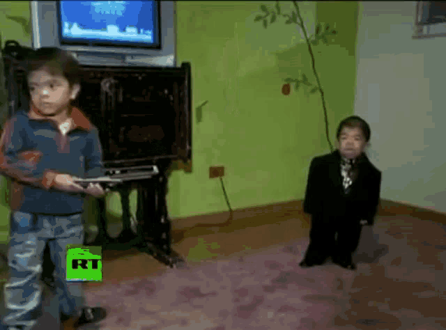 two young boys are playing a video game in front of a television with the letters rt on the screen