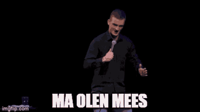 a man in a black shirt is holding a microphone and the words ma olen meees are above him