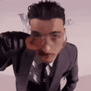 a man in a suit and tie is wearing glasses and a nose ring