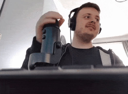 a man wearing headphones and a microphone looks at the camera