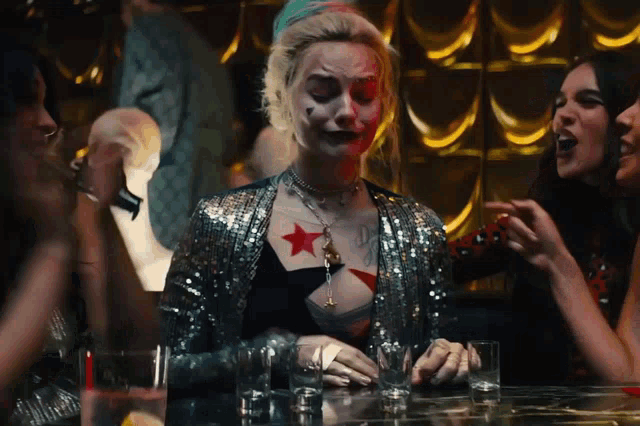 a woman with a star tattoo on her chest sits at a table
