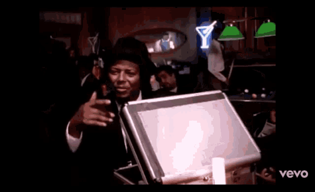 a man in a suit and tie is holding a briefcase in a room .