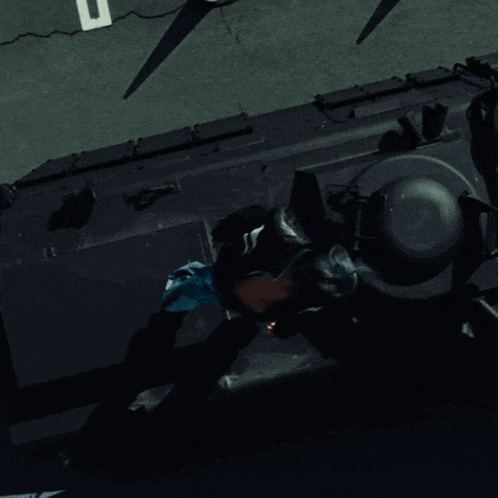 a woman is laying on the back of a black vehicle