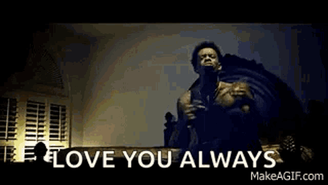 a man is standing in front of a microphone with the words `` i love you always '' written on the screen .