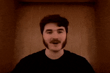 a man with a mustache giving a thumbs up
