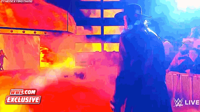 a man in a cowboy hat is standing in front of a wwe live sign