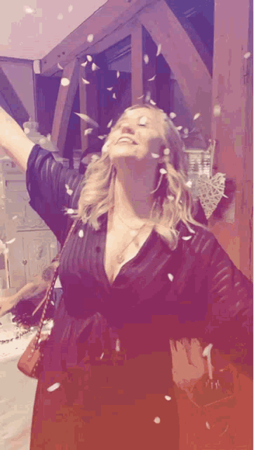 a woman in a black dress is throwing petals in the air with the number 1 in the background