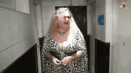 a woman in a leopard print dress is standing in a hallway