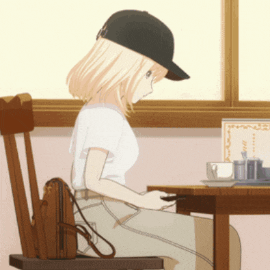 a girl wearing a baseball cap sits at a table