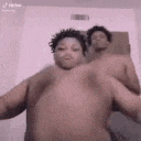 a shirtless man is dancing with another shirtless man in a room .