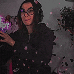 a woman wearing glasses and headphones is standing with her arms outstretched and the words ah hum written on the bottom .