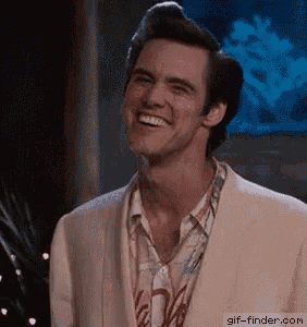 a man in a suit is smiling in front of a fish tank .