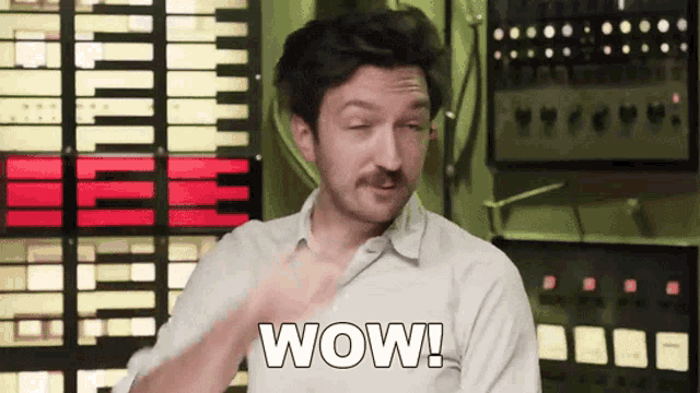 a man with a mustache says wow in front of a keyboard