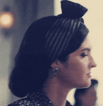 a woman wearing a striped headband with a bow in her hair