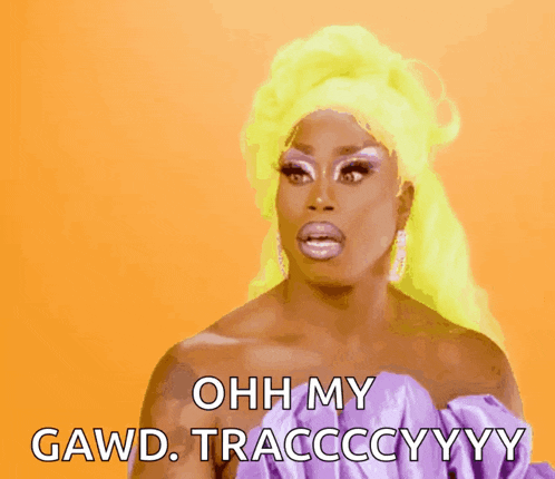 a drag queen with yellow hair says ohh my gawd tracccyyy