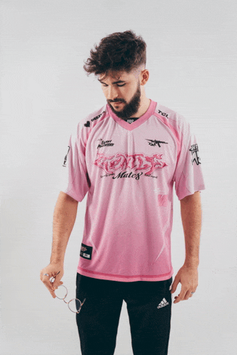 a man wearing a pink shirt that says " mates " on it