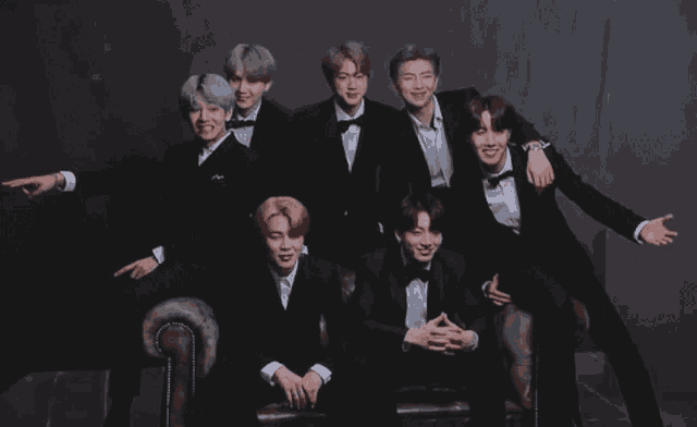 a group of men in tuxedos pose for a photo