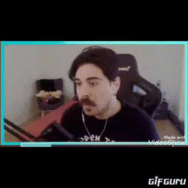 a man with a mustache is sitting in front of a microphone in a video game .