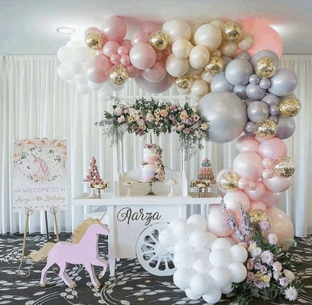 a table decorated with balloons and flowers for a birthday