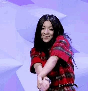 a woman wearing a red plaid shirt is smiling and dancing