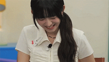 a young woman wearing a white shirt with the number 8 on it is smiling .