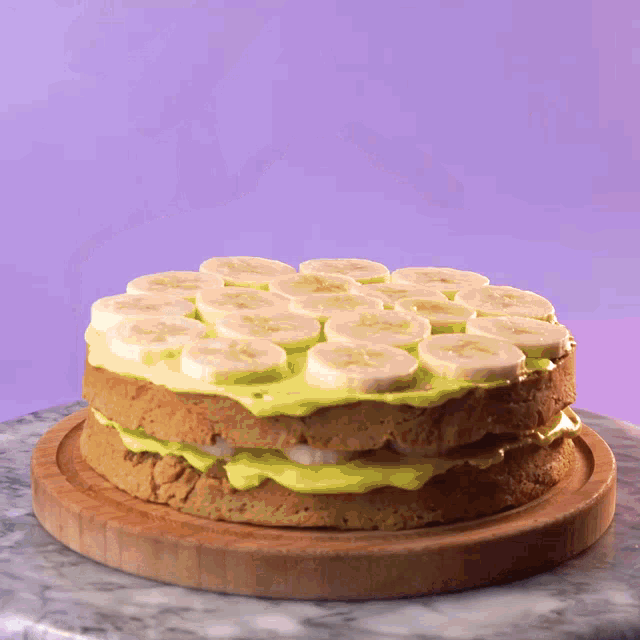 a banana cake on a wooden cutting board with a purple background