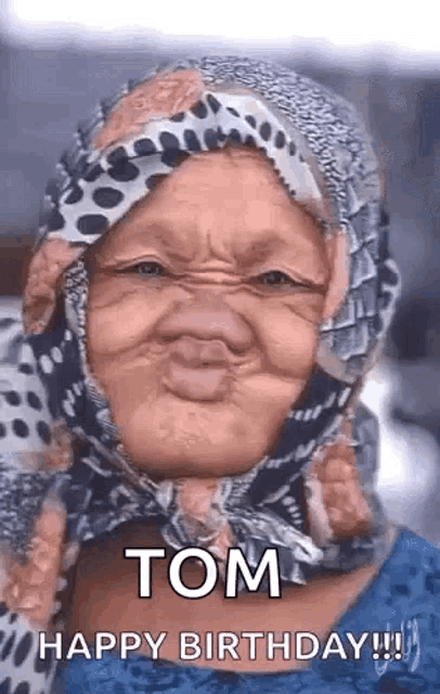 an elderly woman wearing a head scarf is making a funny face .