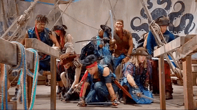 a group of people dressed in pirate costumes with swords and ropes